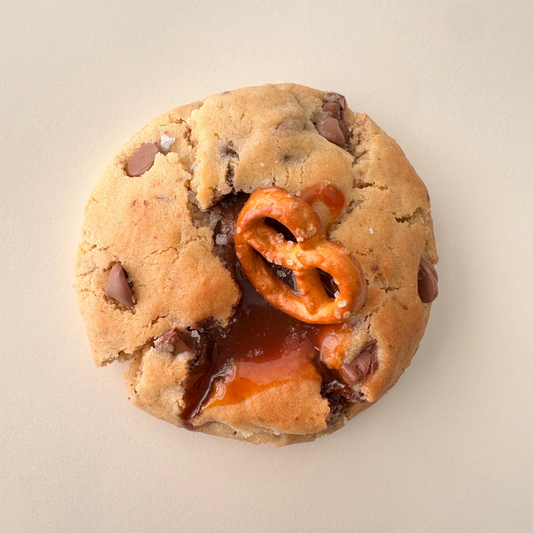 Cookie with a caramel and pretzel center on a beige background